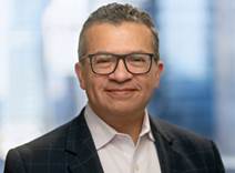 A person wearing glasses and a suit